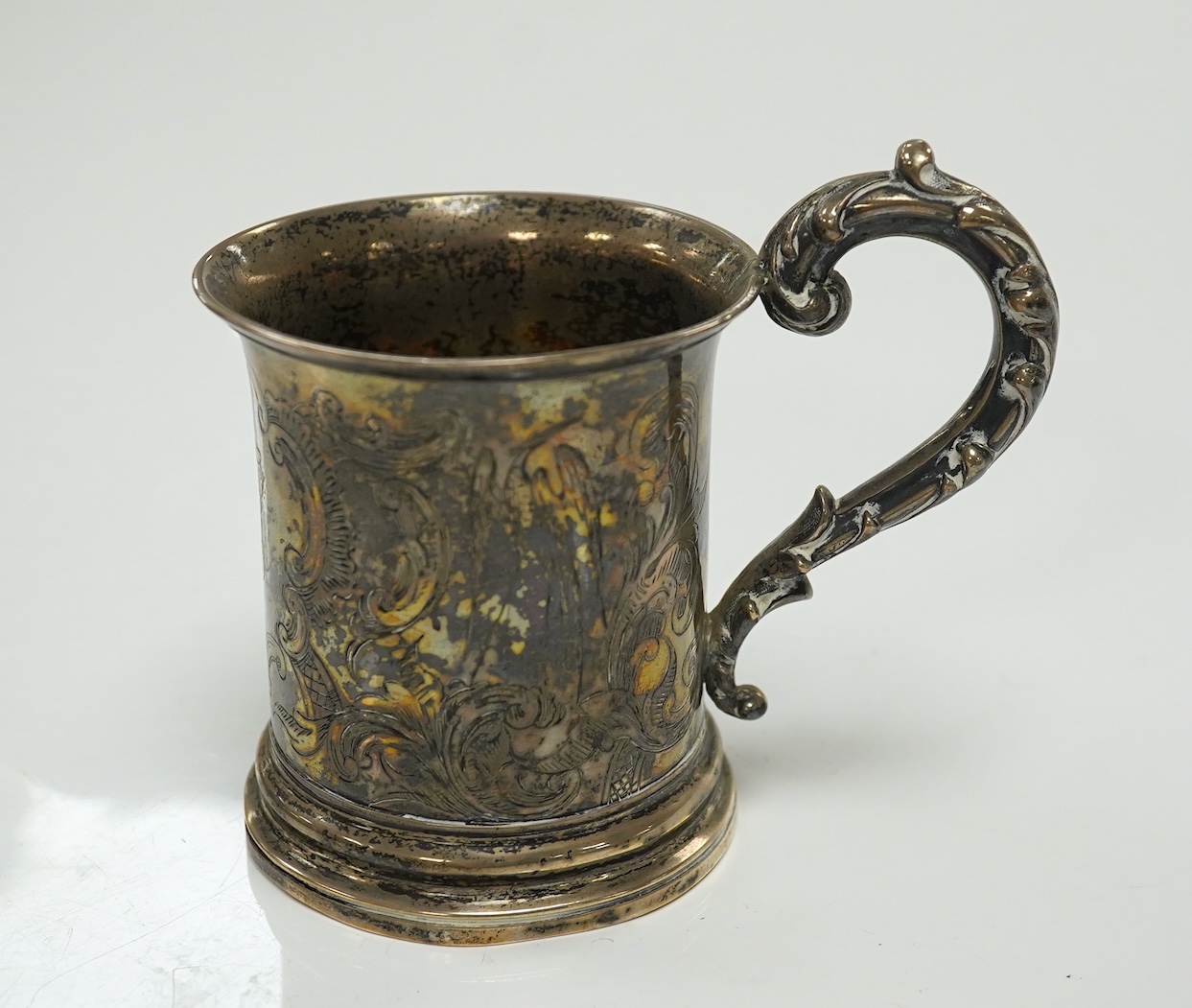 A George V Brittania standard silver kitchen pepper, by John Charles Lowe, London, 1935, 11.5cm and a Victorian silver christening mug, 10.4oz. Condition - poor to fair